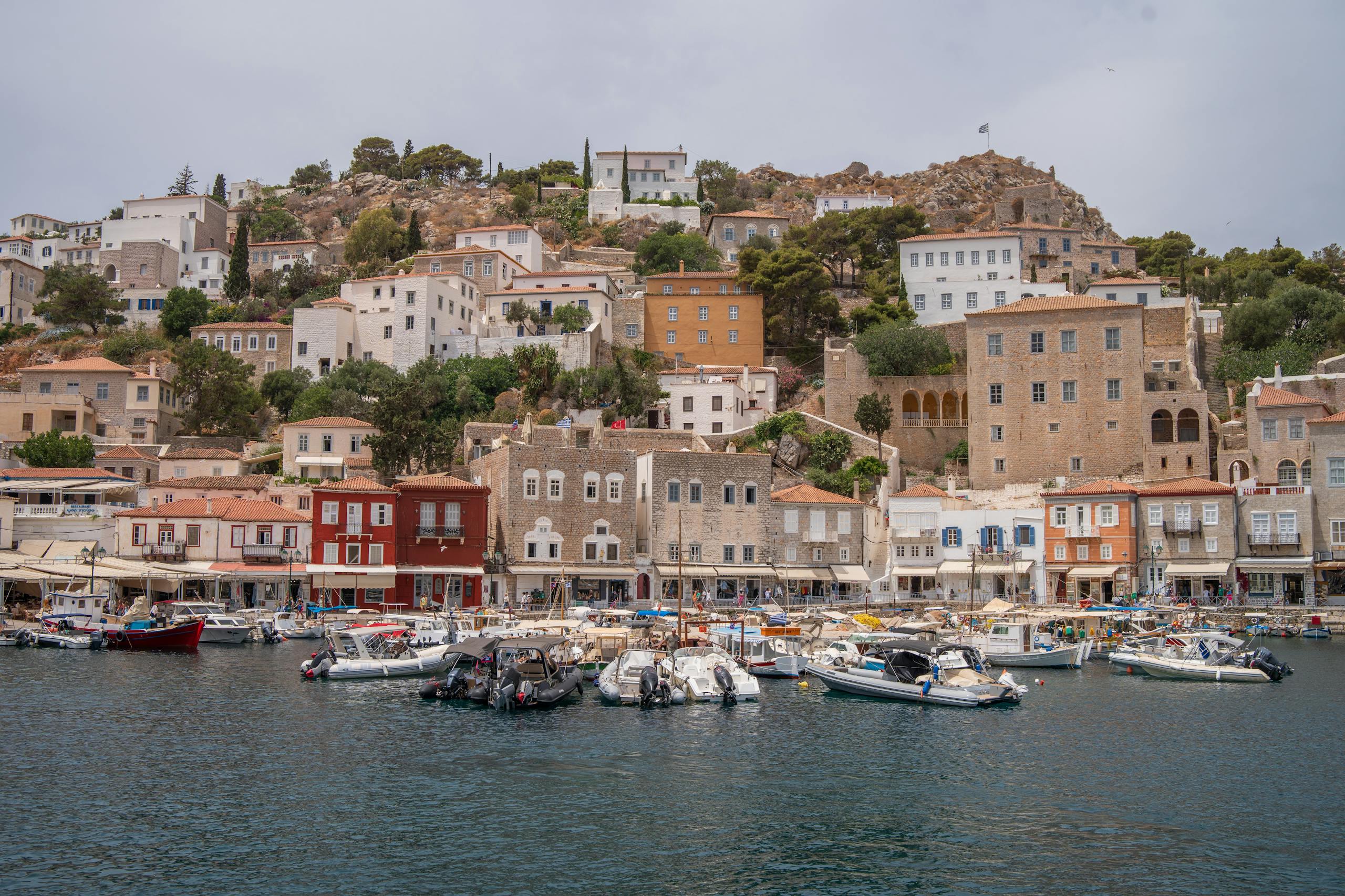 Charming waterfront view of a Greek town with boats and traditional houses.