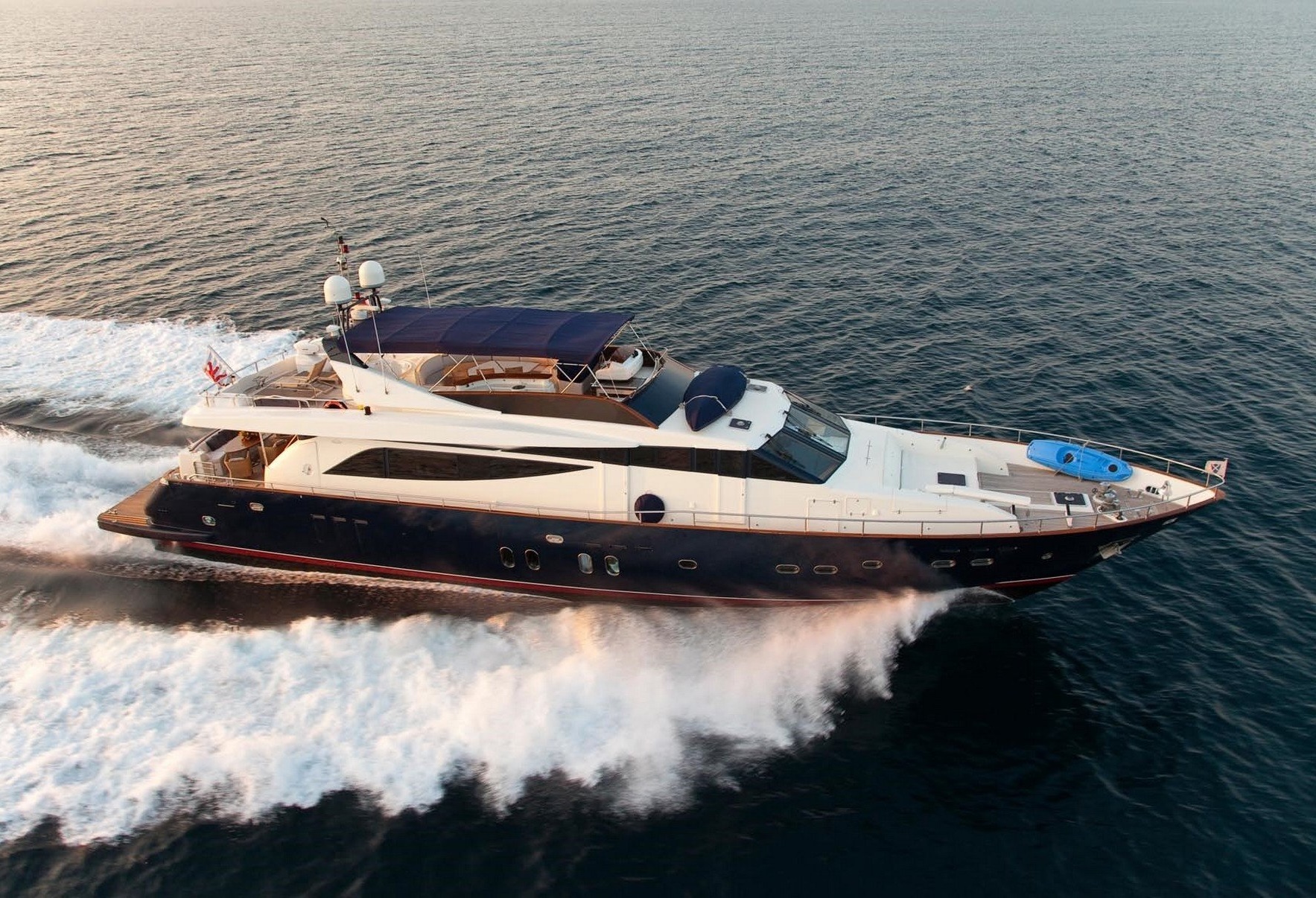 ATALANTI luxury yacht cruising at high speed through calm sea during golden hour.
